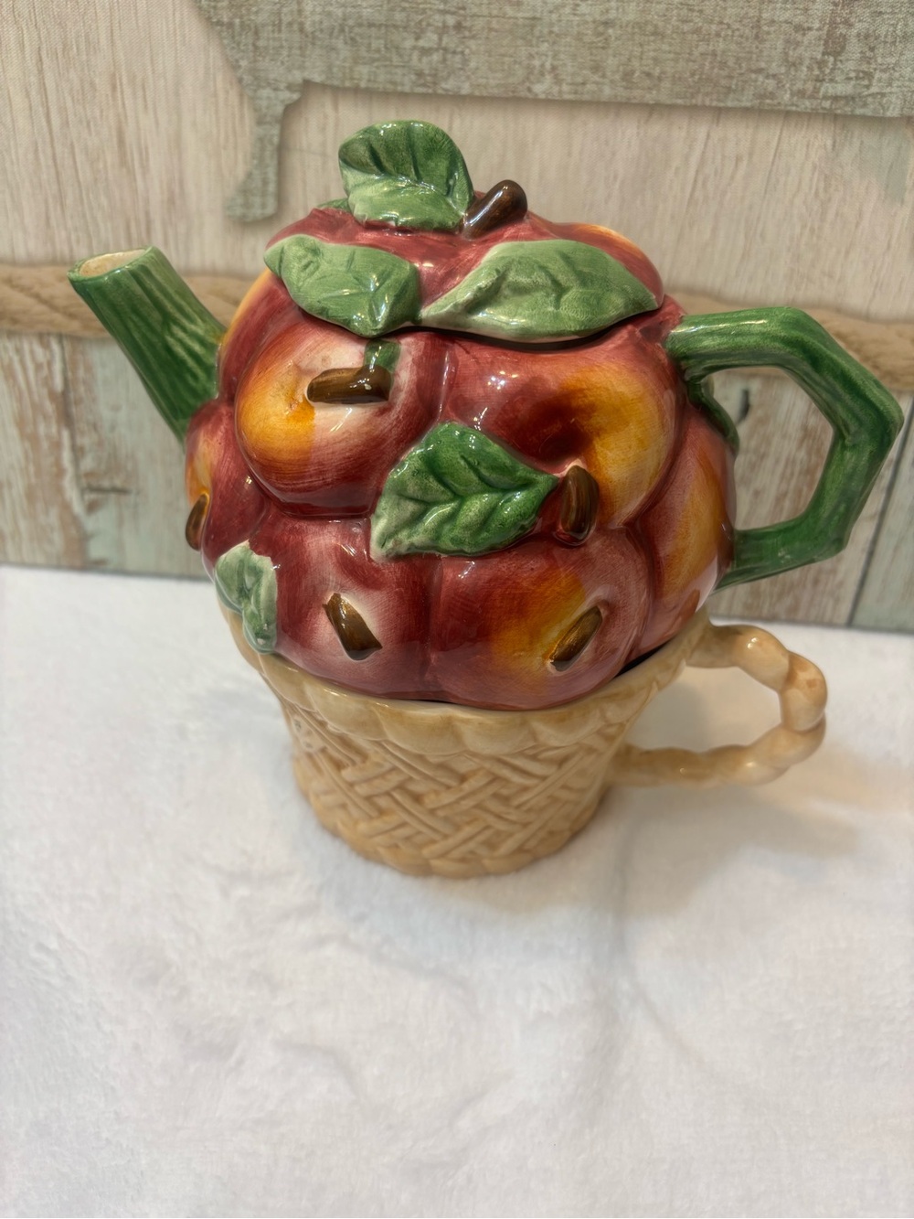 Vintage 1990s ceramic tea set features a teapot with apples and a mug.